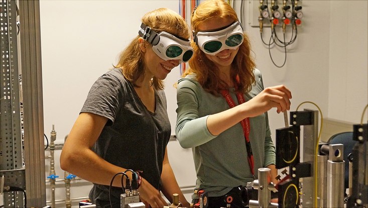 Zwei Studentinnen mit Schutzbrillen in einem Physiklabor