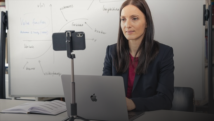 Frau vor Laptop und Handy