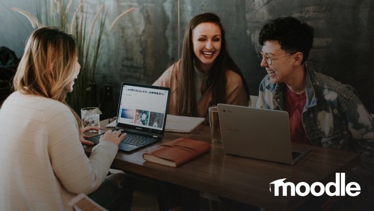 Lachende Gruppe vor Laptops