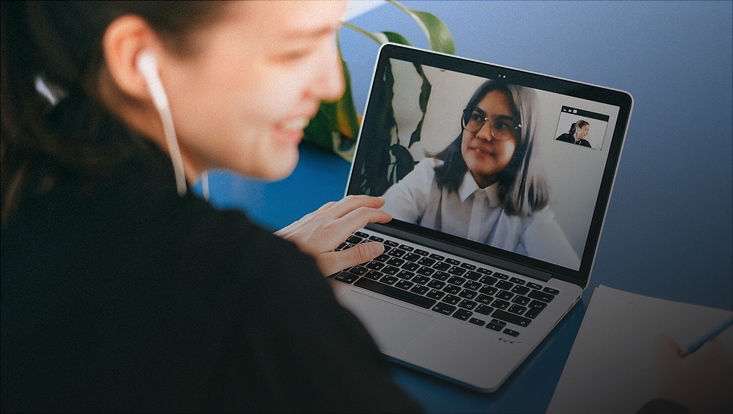 Lachende Frau bei Videokonferenz am Laptop