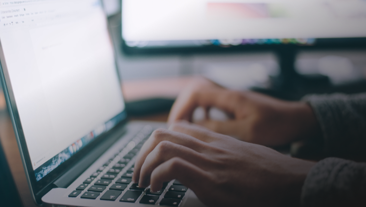 Person tippt auf Laptop-Tastatur