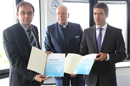 Empfang bei Universitätspräsident Prof. Dr. Dieter Lenzen: Der parlamentarische Staatssekretär beim BMBF Stefan Müller (r.) überreicht Prof. Dr. Peter Schleper (li.) vom Institut für Experimentalphysik die Bewilligungsurkunden. Bild: UHH/Schoettmer